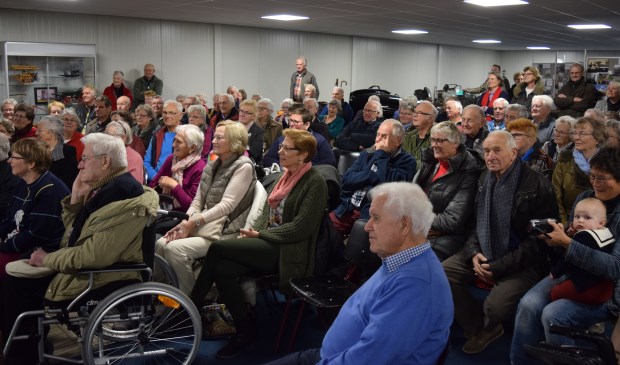 Een afgeladen zaal luistert naar de verhalen over vroeger