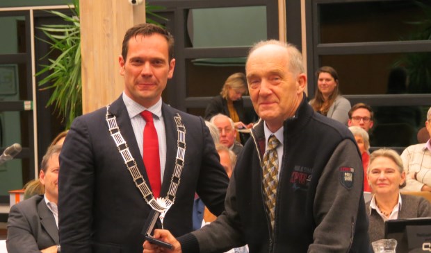Burgemeester Sjoerd Potters reikt Nico Jansen de Chapeaupenning van de gemeente De Bilt uit.