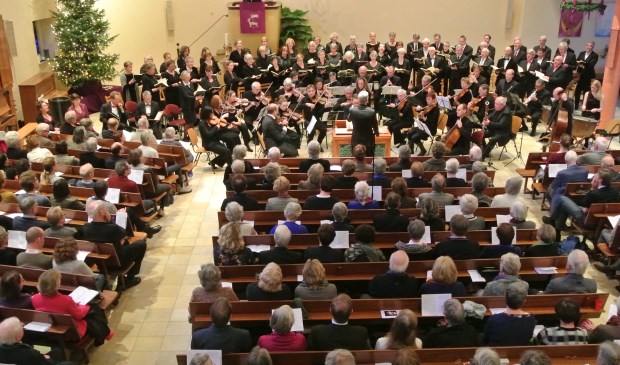 Het koor, orkest en solisten in een volle kerk