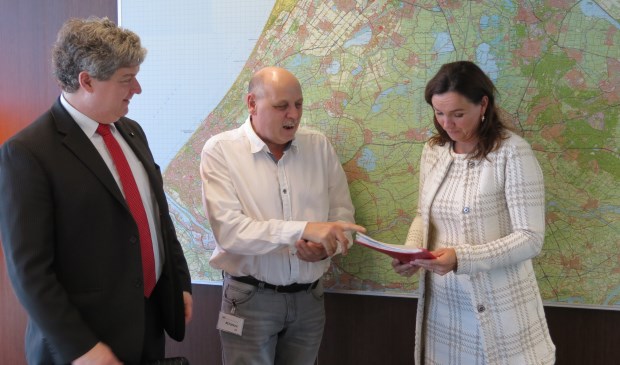Onder toeziend oog van gemeenteraadslid Christiaan van Nispen tot Sevenaer overhandigt Herman Kramer de handtekeningen aan gedeputeerde Jacqueline Verbeek.
