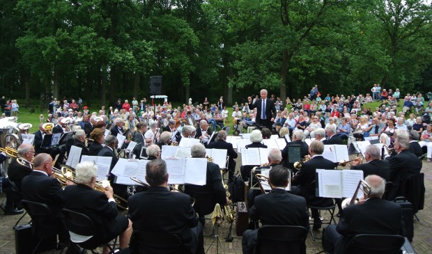 Op de voorgrond het Senioren Harmonie Orkest, o.l.v. Ton van Overdam, met het massaal toegestroomde publiek op de achtergrond.