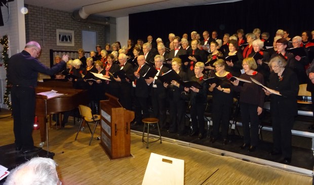 Een goed gevulde zaal geniet van de vocale prestaties van beide koren.