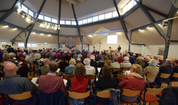 Een volle centrumkerk luistert naar het verhaal van burgemeester Potters.