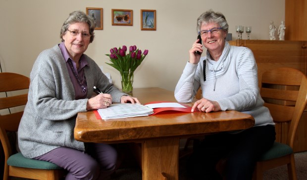 Trijnie Spoelstra en Boukje Andringa (r) zijn druk met de telefooncirkel.