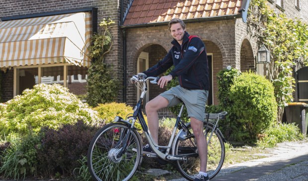 Job Paauw op een e-bike voor het huis van zijn ouders, waar hij zijn bedrijf begonnen is.