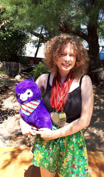 Julia met haar prijzen en de mascotte van de WSC: een Alpaca.