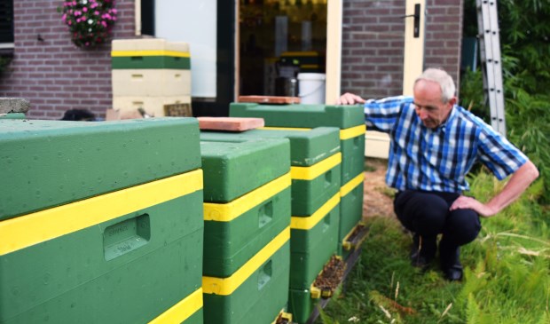 Aart van der Linden met een paar van zijn bijenkasten.
