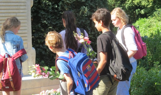 Leerlingen van de Groen van Prinstererschool leggen bloemen bij het monument.