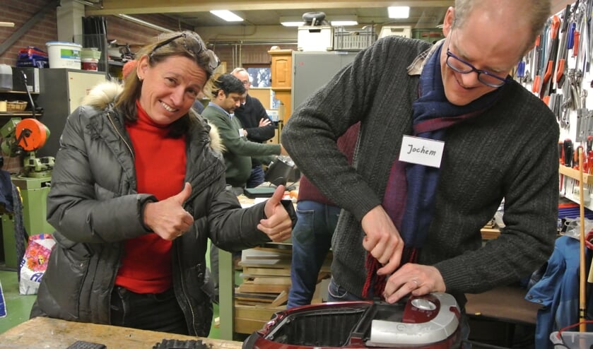 Ditte is blij want reparateur Jochem krijgt haar stofzuiger weer aan 't werk. (foto Frans Poot)