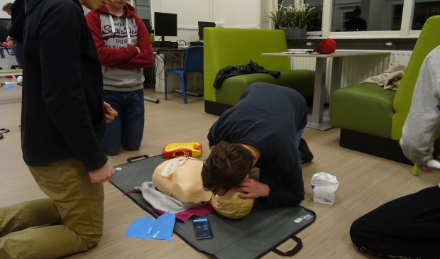De leerlingen zijn heel geconcentreerd aan het oefenen op de oefenpop en helpen elkaar wanneer nodig.