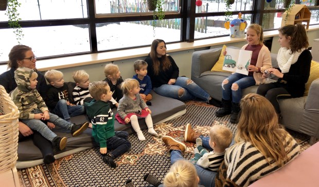 Leerlingen uit groep 6 lezen voor aan de peuters.