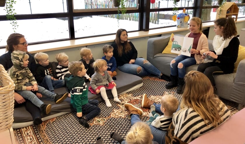 Leerlingen uit groep 6 lezen voor aan de peuters.