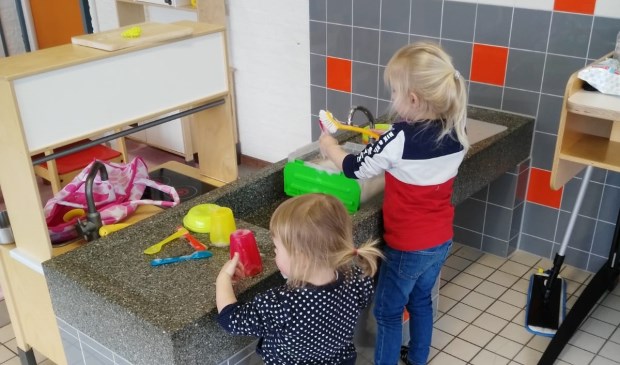 Vol aandacht wordt de vuile vaat afgewassen.