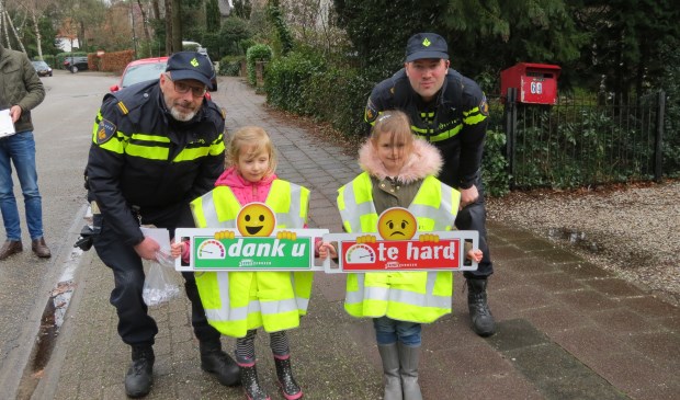 Nomi en Michelle, met het bord 'te hard', verleenden met veel enthousiasme hun medewerking aan de actie.