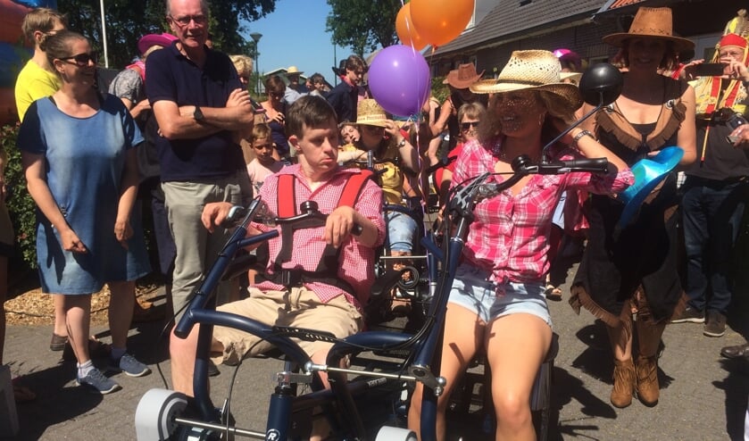 De 4-fiets wordt binnengereden door medewerker Bettine van Ginkel samen met drie bewoners onder muzikale begeleiding van Kunst & Genoegen.
