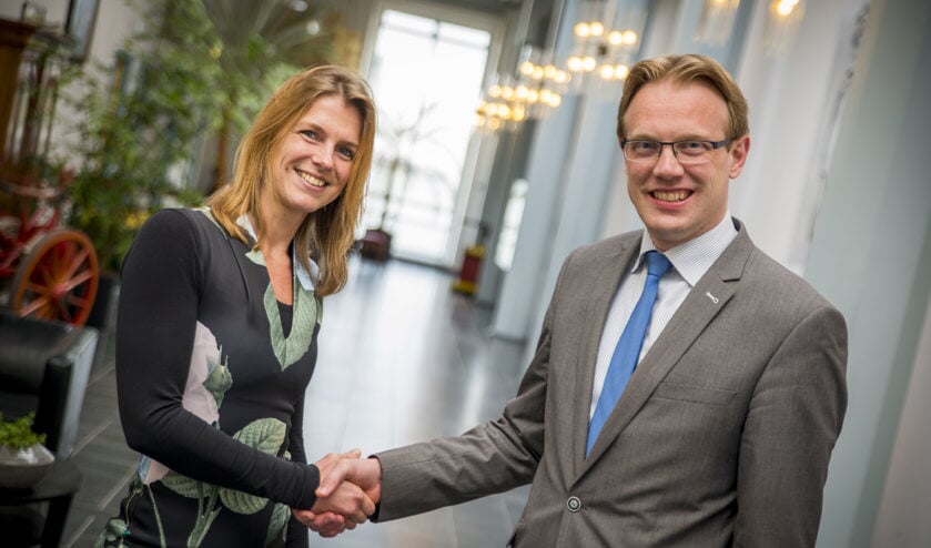 Wethouder Peter Verheij, bestuurlijk opdrachtgever voor de renovatie van het gemeentehuis, schudt architecte Richelle de Jong van DP6 de hand als symbolische bekrachtiging van de gunning.