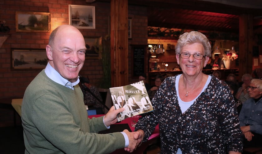 • Na de lezing door Geert Ouweneel, die vertelde over dijkdoorbraken in de Alblasserwaard, overhandigde voorzitter Wilbert de Jong het eerste boekje aan mevrouw Veen-den Besten.