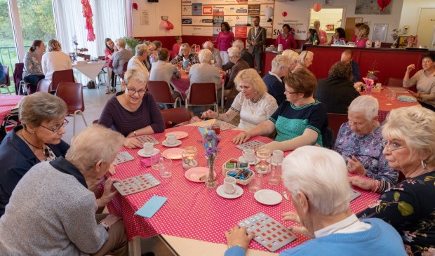 • Een spelletje bingo tijdens de verwendag, met wethouder Kraijo op de achtergrond.