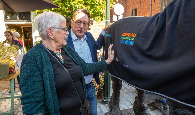• Wethouder Frank Meurs en oud-wethouder Thea Schaafsma leggen een deken op het bronzen beeld 'Het Paard', dat deze week weer teruggeplaatst is na de afronding van de bestratingswerkzaamheden aan de Voorstraat.