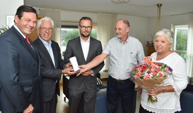 Gedeputeerde Rik Janssen (links) en wethouder Arjan Kraijo (midden) overhandigen de eerste luchtkwaliteitsmeter aan Bram en Lya Hoeijenbos (rechts).