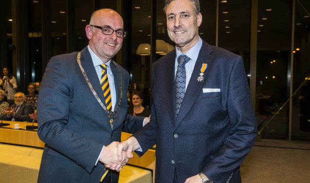 • Burgemeester Martijn Vroom met Hans Butter (rechts), net na de uitreiking van de koninklijke onderscheiding.