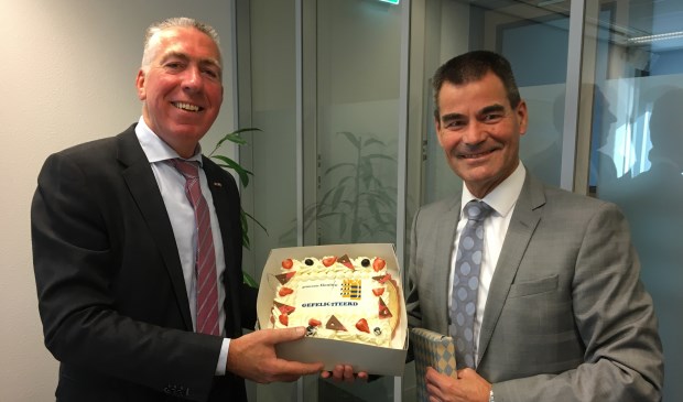 • Burgemeester De Jong van de gemeente Houten overhandigde wethouder Gijs van Leeuwen (l) een taart, voorafgaand aan de collegevergadering van Zaltbommel.