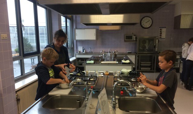 • Docente Vivian Peeters met twee leerlingen aan het werk.