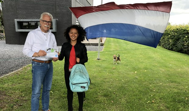 • Voorzitter Arie Slob overhandigt een felicitatiekaart aan Victoria de Jong.