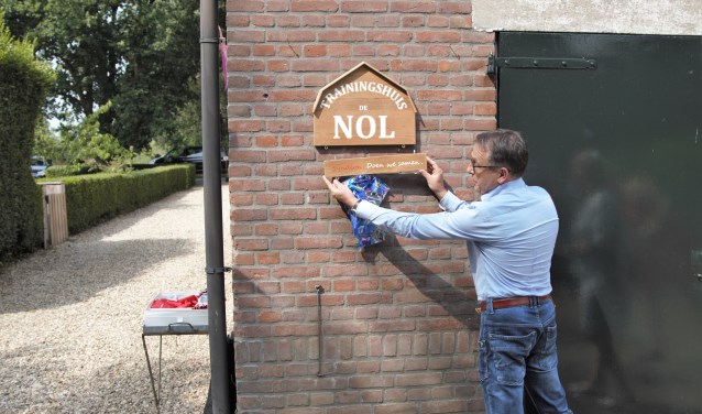 • Bestuurder Harry Vogelaar bevestigt het naambord bij de officiele opening van Trainingshuis De Nol.