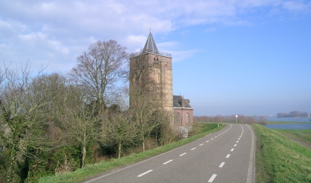 • De Waalbandijk met de dikke toren van Varik.