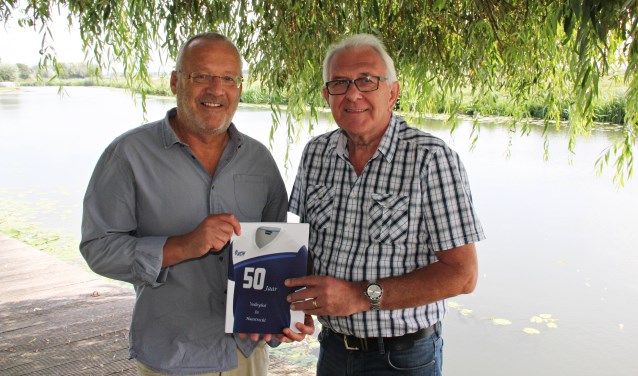 • Voorzitter Ron de Ruiter (l) en samensteller Gerard Merkus met het jubileumboek.