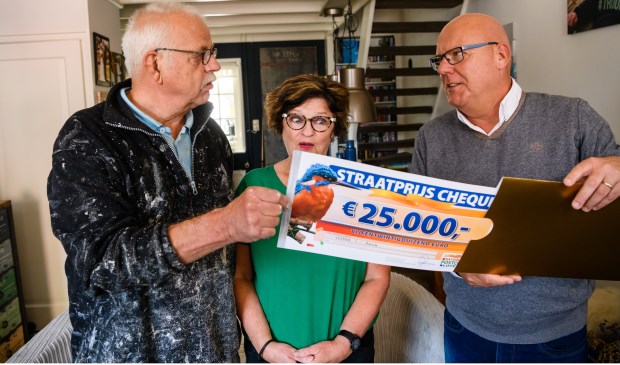 Jan Willem en zijn vrouw uit Ameide worden verrast door Postcode Loterij-ambassadeur Gaston Starreveld met de PostcodeStraatprijs-cheque