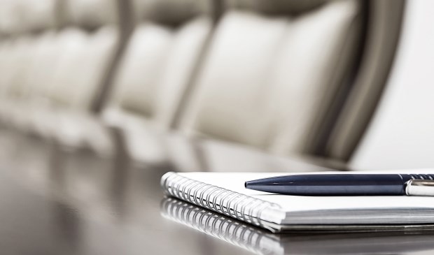 Closeup of notepad kept on table in empty conference room
