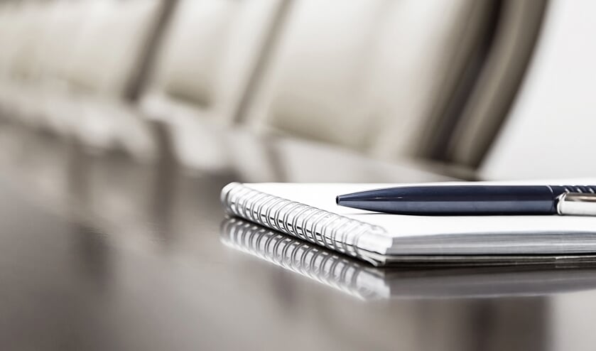 Closeup of notepad kept on table in empty conference room