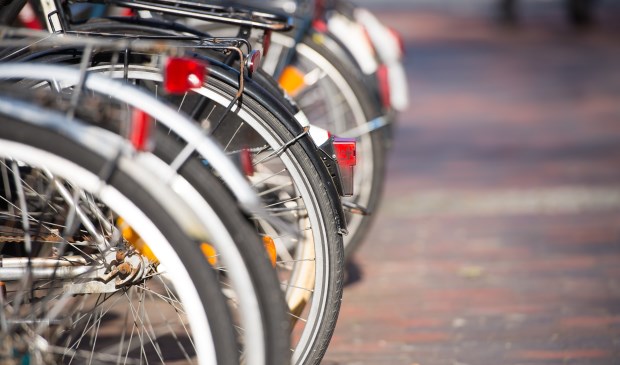Close up of bicycles wheels parked in a row in the city, blurred background and copy space.