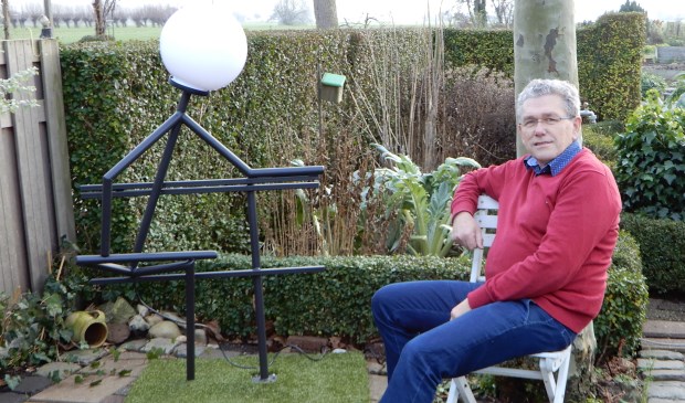 • Wim Breedijk bij een kunstwerk dat hij bij zijn afscheid van collega's heeft gekregen.