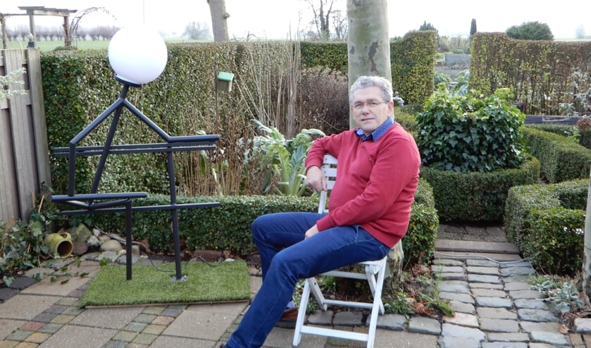 • Wim Breedijk bij een kunstwerk dat hij bij zijn afscheid van collega's heeft gekregen.