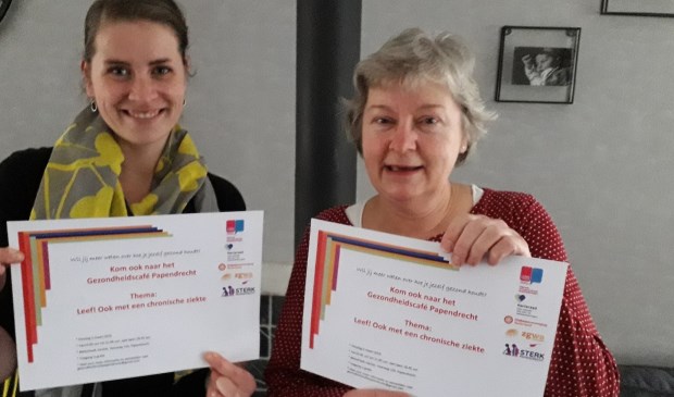• Pauline en Gaby met de uitnodiging van het Gezondheidscafé.