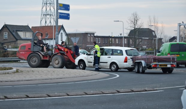 • Een van de voertuigen wordt door een shovel weggehaald.