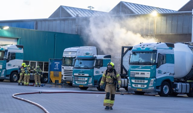 • Brandweerlieden bij de lekkende tankwagen, het waterscherm wordt aangelegd.