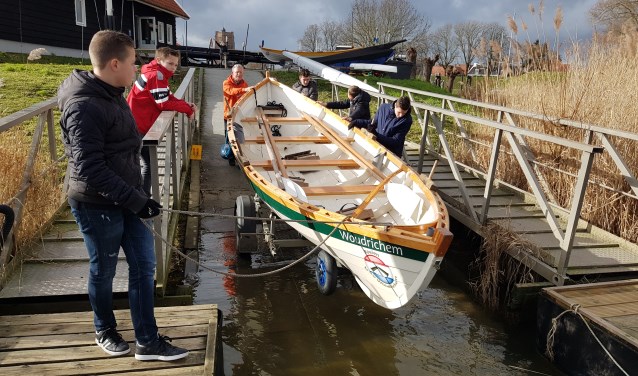 De leerlingen laten samen met Goof van Vliet een St. Ayles Skiff te water.