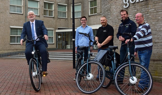 • Wethouder Bert Bening rijdt onder het toeziend oog van de leveranciers een eerste rondje.