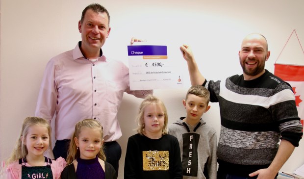• Stephan van Velduizen (Rabobank Krimpenerwaard) overhandigt de cheque aan Bram de Jong. De kinderen op de foto zijn v.l.n.r.: Joney, Viënne, Karlijn en Marius.