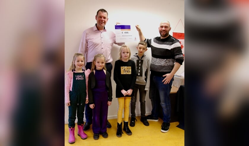 • Stephan van Velduizen (Rabobank Krimpenerwaard) overhandigt de cheque aan Bram de Jong. De kinderen op de foto zijn v.l.n.r.: Joney, Viënne, Karlijn en Marius.