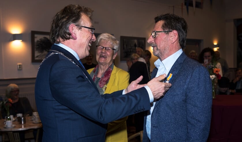 • Burgemeester Keereweer speldt de Koninklijke Onderscheiding op.