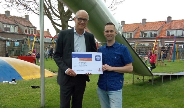 • De heer Spijk (links) overhandigt de cheque aan Pleun Meerkerk.