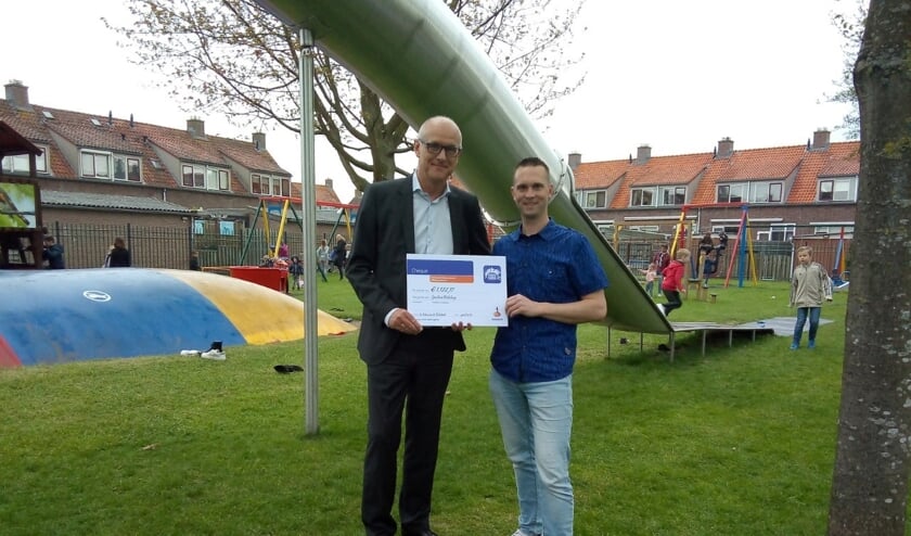 • De heer Spijk (links) overhandigt de cheque aan Pleun Meerkerk.