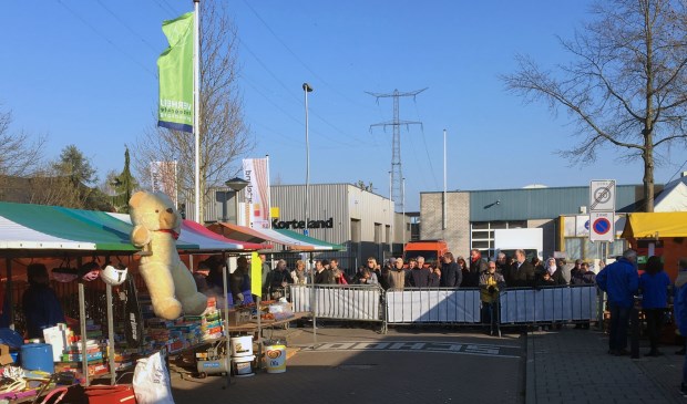 • Wachten bij de dranghekken voor de start van de rommelmarkt.