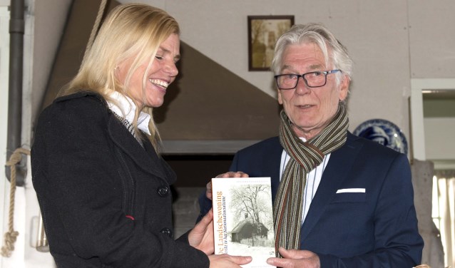 Paula Jorritsma krijgt uit handen van Bert van Straten het eerste exemplaar van 'De Landschewoning'.