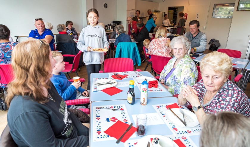• De buurtbewoners aan de gezellige gedekte tafels.